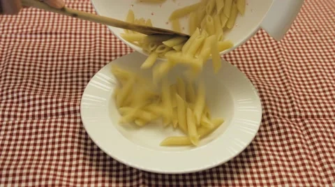 Pouring basic Italian pasta in a dish Stock Footage 63428614