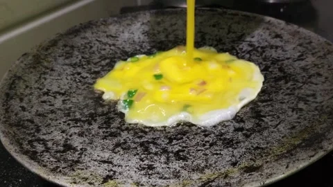 Pouring Beaten Egg Mixture onto Hot Pan for Homemade Omelette Cooking Close up Stock Footage 338225171
