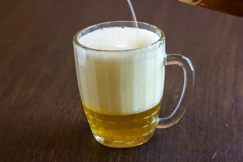 Pouring beer from bottle into mug at bar Stock Photos