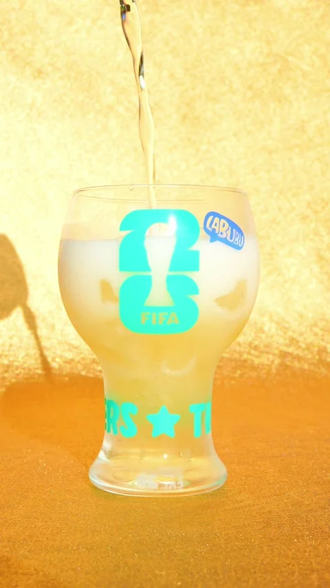 Pouring beer to a cup of THE MONSTERS x FIFA SERIES-Glass Cup Stock Footage 337478291