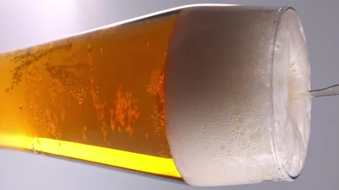 Pouring beer into a glass capturing the foam and golden liquid in four frames Stock Footage 338120912