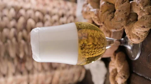 Pouring beer into the glass. Wheat spikelets with one mugs of beer on wooden Stockbeeldmateriaal 204872934
