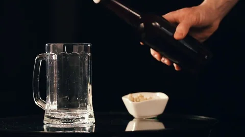 Pouring beer into mug on black background Video stock 75659822