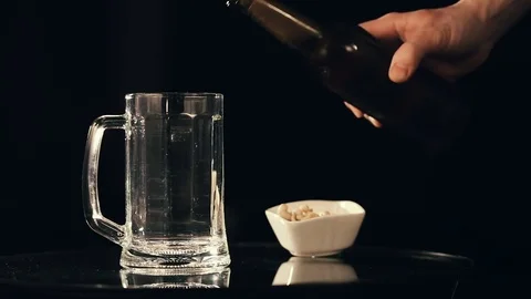 Pouring beer into mug on black background Stockbeeldmateriaal 75659868