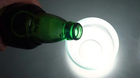 Pouring beer into a mug, motion shot. Beer pouring into glass on a textured Stock Footage 101077312