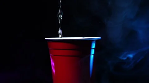 Pouring beer into a red solo cup with party lights and smoke Stock Footage 257514976