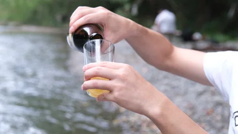 Pouring beer by the river MOV Stock-Footage 168226550