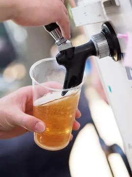 Pouring beer from a server at an event. Stock Photos