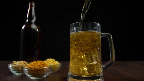 Pouring beer into a transparent half-filled glass of beer - Party time Stock Footage 162017608