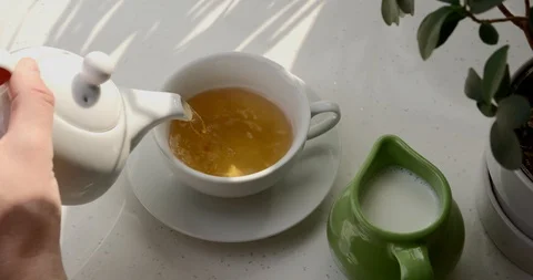 Pouring black ceylon tea teapot into cup Stock Footage 126722740