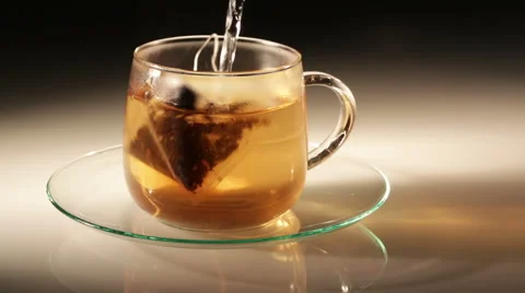Pouring black tea in cup with pyramid bag Vídeo Stock 57722759