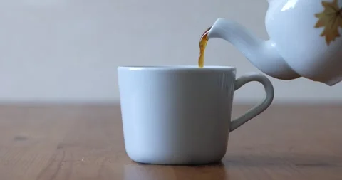 Pouring Black Tea Infusion into Ceramic Cup Side View Real Time Stock Footage 340849836