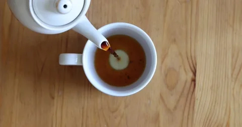 Pouring Black Tea Infusion into Empty Ceramic Cup Top View Stock Footage 340849520