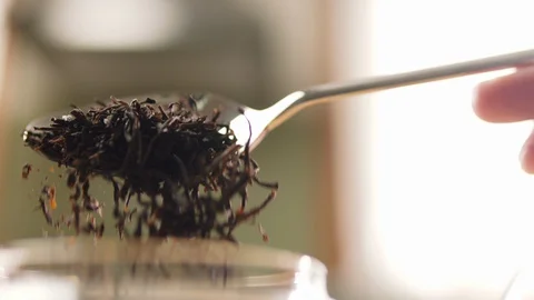 Pouring black tea in slow motion with spoon. 動画素材 128738529
