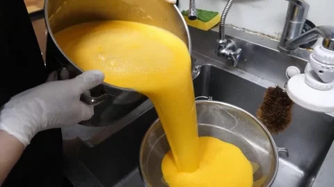 Pouring Blended Raw Eggs Through a Wire Mesh Strainer in a Kitchen Sink 스톡 동영상 347688729