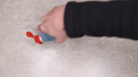 Pouring blue detergent onto a beige kitchen table and cleaning with a yellow rag Stock Footage 120450426