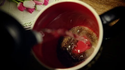 Pouring boiling water into a black mug  with instant coffee and sugar inside Stock Footage 109402004