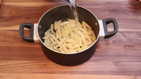 Pouring Boiling Water Over Penne Pasta in Cooking Pot Slow Motion Stock Footage 334808548