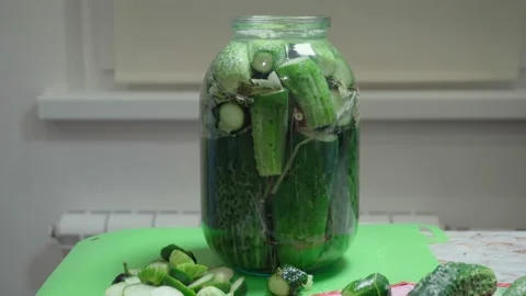 Pouring brine into a jar of cucumbers. Video stock 141317628