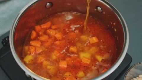 Pouring broth to fried vegetables with spices Video stock 252180321