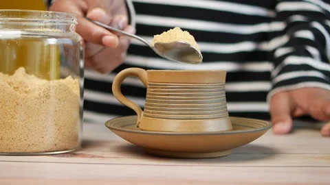Pouring brown sugar in a cup of tea Stock Footage 230487272