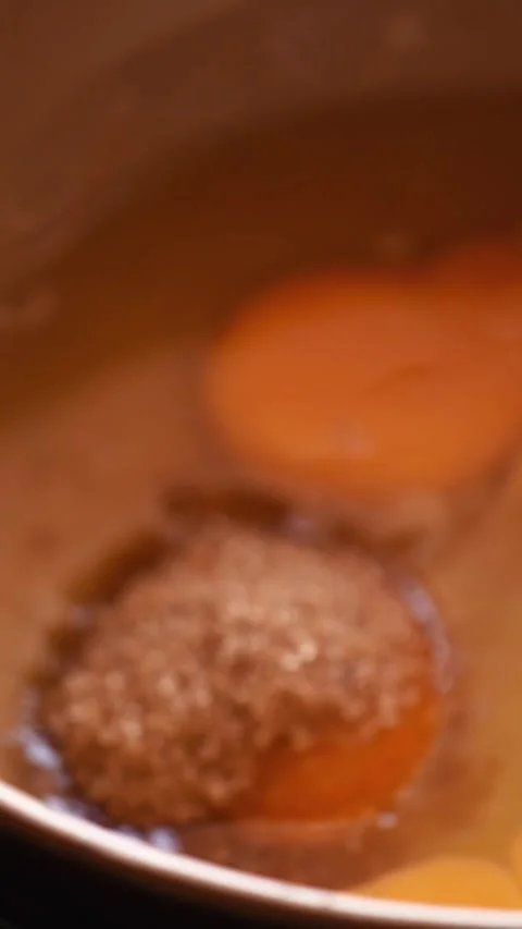 Pouring Brown Sugar onto Egg Yolks for Perfect Mixing Stock Footage 299621937