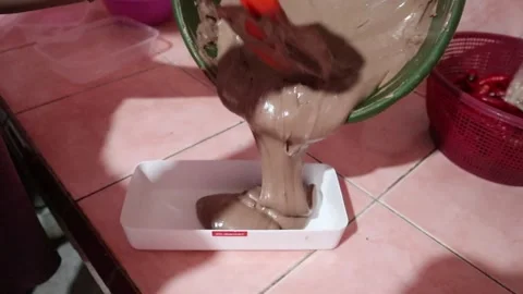 Pouring cake batter into a mold, preparing for baking Stock Footage 303200788