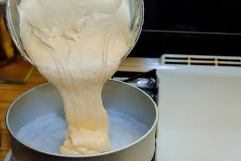 Pouring cake dough into a baking pan. Stock Photos
