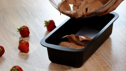 Pouring cake mix into baking tin. Stock Footage 90939563