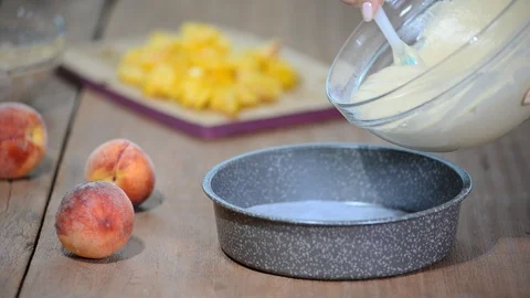 Pouring cake mixture into tin. Making pastry dough. Making peach cake. Stock Footage 93933611