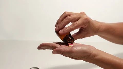 Pouring capsules from a bottle into your hand Stock Footage 249973468
