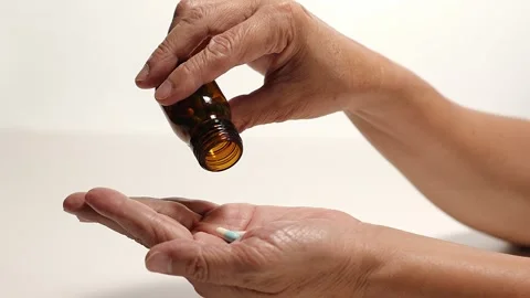 Pouring capsules from a bottle into your hand Stock Footage 249973473