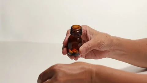 Pouring capsules from a bottle into your hand Stock Footage 249973479