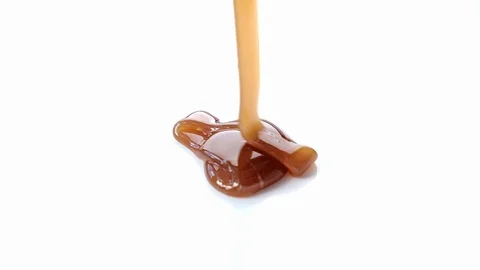 Pouring caramel syrup on white background Stock Footage 101489784