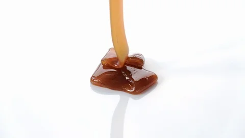 Pouring caramel syrup on white background Stock Footage 101489788