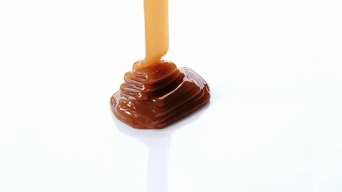 Pouring caramel syrup on white background Stock Footage 101489790