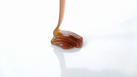 Pouring caramel syrup on white background Stock Footage 101489791