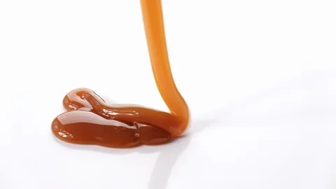Pouring caramel syrup on white background Stock Footage 101489800
