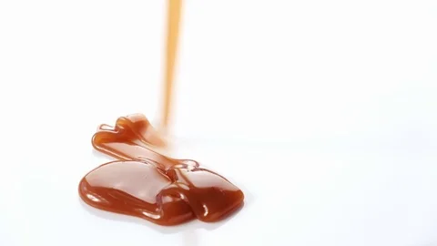 Pouring caramel syrup on white background Stock Footage 101489801