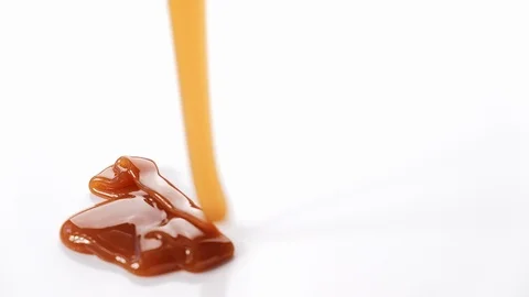 Pouring caramel syrup on white background Stock Footage 101489808