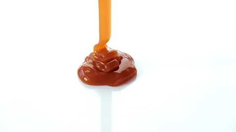 Pouring caramel syrup on white background Stock Footage 101489867