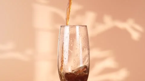 Pouring a carbonated drink into a glass, close up. Cola sparkling drink. Stock Footage 299373853