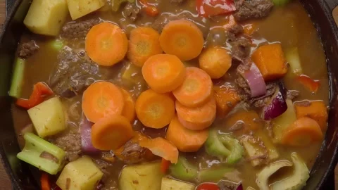 Pouring Carrots into Beef and Vegetable Stew, Top View Stock Footage 316086609