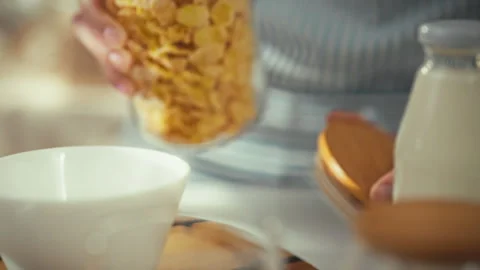 Pouring cereal into a bowl as part of a healthy breakfast routine at home Stock Footage 323874053