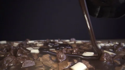Pouring chocolade sauce over chocolade pizza dish in slowmotion slide 動画素材 124017713