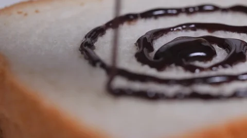 Pouring the chocolate on the bread slices Stock Footage 128180631