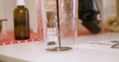 Pouring chocolate into measuring cup, close up shot in 4K. Stock Footage 125110871