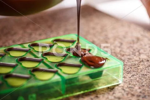 Pouring chocolate in mold Stock Photos