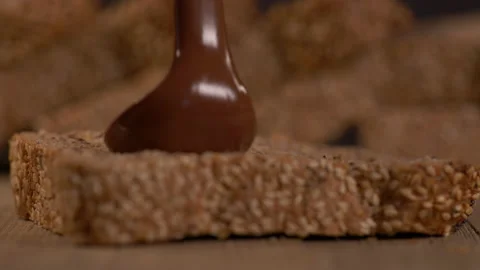 Pouring Chocolate Spread on a Loaf Of Bread Stock Footage 130448071