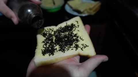 Pouring a chocolate sprinkle in covered bread by butter Video stock 278509811